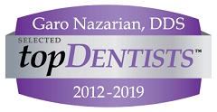 The image features a logo with text elements. It includes a graphic with a ribbon design at the top, inside which is a name Garo Nazarian, followed by the title DDS. Below this, there s a badge that reads TOP DENTISTS and the years 2012-2019. The logo has a purple background with white text and a silver emblem.